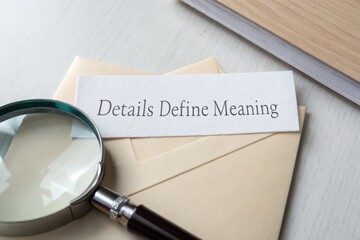 Magnifying glass over paper with the phrase Details Define Meaning