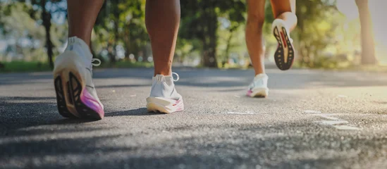 Fototapete Rund Laufen Runners jogging on asphalt road in park with sunlight  © escapejaja