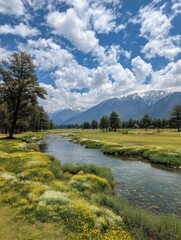 Serene river flows through valley with mountains under blue sky and clouds in Kashmir India wide shot