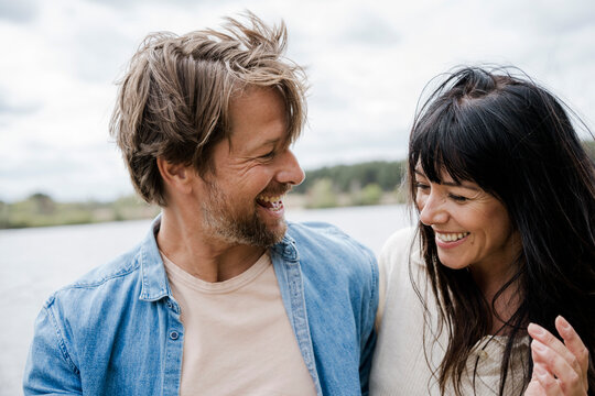 Couple smiling and talking outdoors in windy natural setting