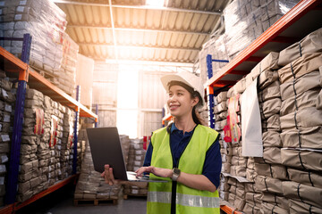 A woman in a green vest is scanning a barcode with a handheld device. She is wearing a yellow vest and is standing in a warehouse © KANGWANS