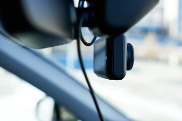 A close-up of a dash cam in a car. A close-up of a dash cam in a modern car against a blurred background. 