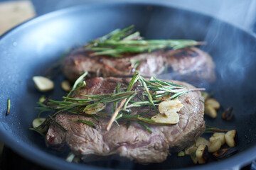 Grilled steaks with rosemary and garlic. The process of cooking beef steaks.
