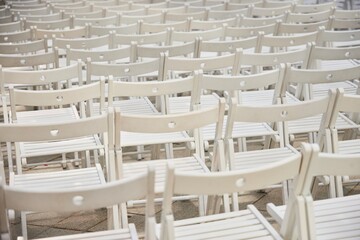 Lots of chairs, standing in several rows. Seating at the event