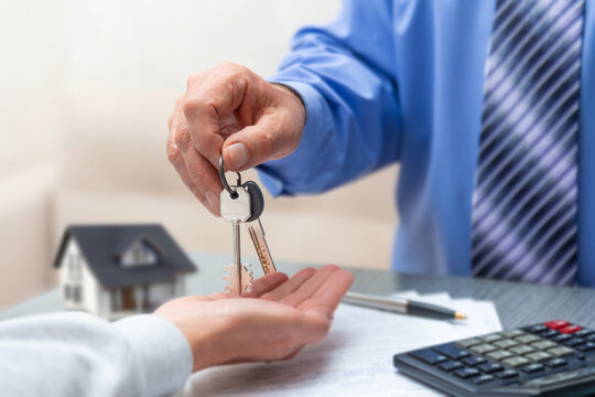 New homeowners receive keys to their dream house during a real estate closing transaction