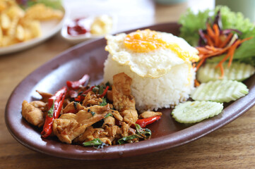 Delicious plate of spicy Thai basil chicken with fried egg