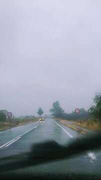 Conducci&oacute;n bajo lluvia: gotas en parabrisas en carretera mojada