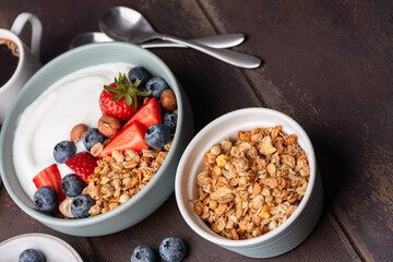 Bowl of crunchy oat honey nut granola served with greek yogurt, blueberries and strawberries