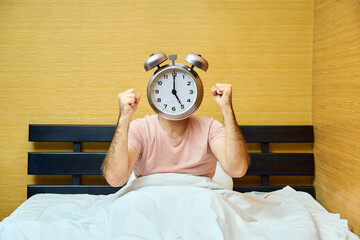 Shocked man with alarm clock instead of head has overslept. Lateness concept