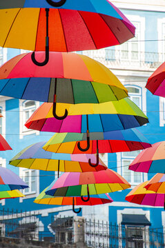 Street Installation of Colorful Umbrellas Between Old City Buildings. Urban art scene. Creative outdoor decoration. Summer tourism attraction. Vibrant lifestyle.