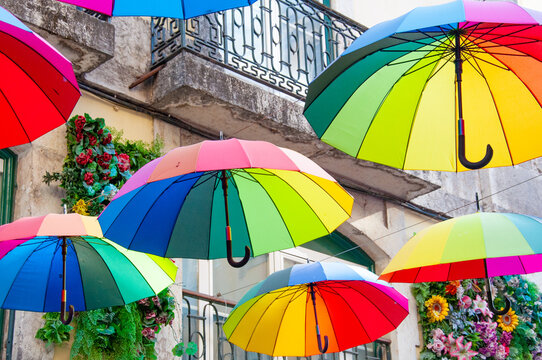 Colorful Umbrellas Over Street Viewed from Below. Abstract urban pattern. Vibrant sky background. Decorative outdoor installation. Perfect background for design