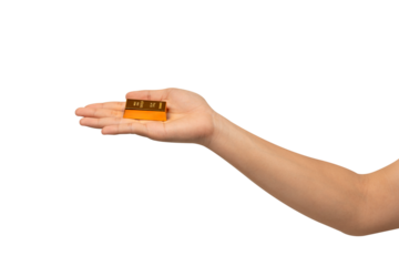 A hand holding a gold bar, isolated on a transparent PNG. This concept is suitable for themes such as gold trading, business, finance, investment, the stock market, wealth, lifestyle and advertising.	