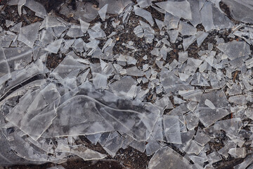 Cracked ice on a puddle texture background cracks and shards on a dark background