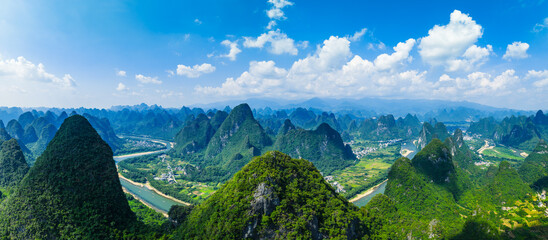 Aerial panoramic view of the famous karst mountain landscape and winding river on a sunny day in Guilin, China.