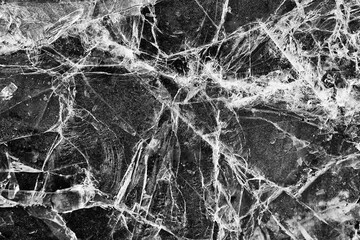 Naklejka na ściany i meble Cracked ice on a puddle texture background cracks and shards on a dark background Naklejka na ściany i meble Cracked ice on a puddle texture background cracks and shards on a dark background