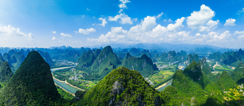 Aerial panoramic view of the famous karst mountain landscape and winding river on a sunny day in Guilin, China.