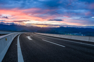 Naklejka premium Curving asphalt highway and mountain with beautiful sky clouds landscape at sunset