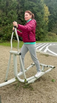Woman exercising on a fitness machine outdoors