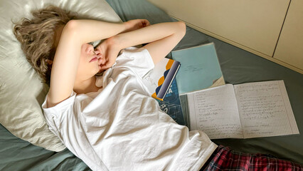 Stressed Teen Lying In Bed With School Books And Notebook For Concepts Of Academic Burnout, Mental Overload, Remote Learning Fatigue, Teen Anxiety, And Relatable Visuals For Youth Support