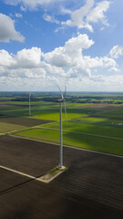 Renewabale energy in the province of Groningen. WInd energy, wind turbines. Energy transistion. Wind turbine surrounded by farmlands.