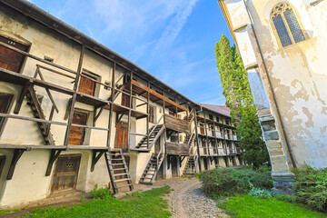 Preserving medieval defensive architecture, the inner wall of Prejmer Fortified Church features old wooden stairs and balconies leading to small rooms. UNESCO site of Romania in Transylvania