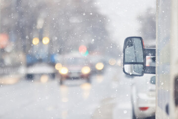 Snowfall on a city highway, blurred background, transport in winter weather, cars