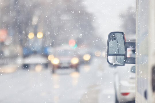 Fototapeta Snowfall on a city highway, blurred background, transport in winter weather, cars