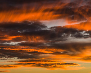 Fototapeta premium Dramatic sunset sky ablaze with vibrant fiery orange and deep crimson clouds painting a breathtaking atmospheric spectacle