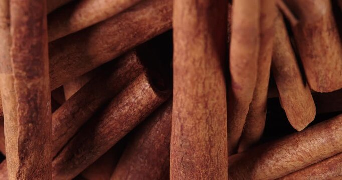 Cinnamon sticks rotate as a background. Fragrant cinnamon close-up. Spices with cinnamon. Food cooking video concept.