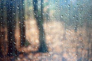 Wet weather, drops of autumn rain on the glass, autumn landscape outside the window, weather change