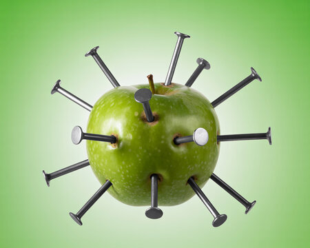 Symbolic green apple pierced with numerous sharp nails representing a painful problem or challenging situation