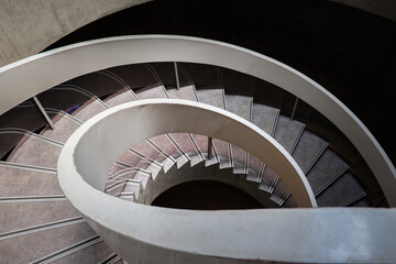 Fototapeta premium Old building interior architecture with a round wooden spiral staircase, metal railing, and steps