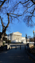 Washington DC Supreme Court building viewed through leafless trees on a sunny day