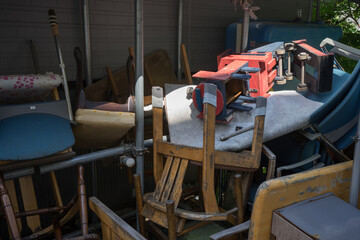 廃棄されてまとめられた椅子