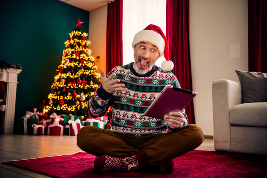 Cheerful elderly man in Christmas sweater enjoying time indoors with festive holiday decorations and vibrant seasonal vibes - Powered by Adobe