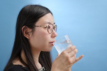 グラスの水を飲む若い日本人女性