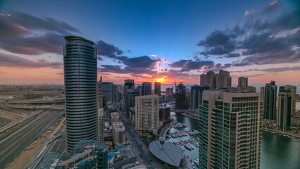 Obraz premium Modern skyscrapers and water channel with boats of Dubai Marina at sunset timelapse, United Arab Emirates.