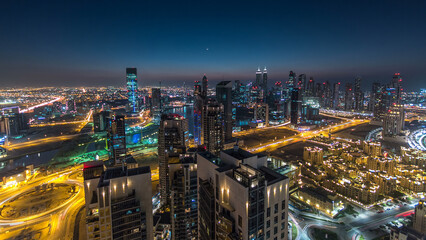 Fototapeta premium Aerial view of a big modern city day to night timelapse. Business bay, Dubai, United Arab Emirates.