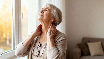 peaceful elderly woman enjoying morning sunlight through window with serene expression