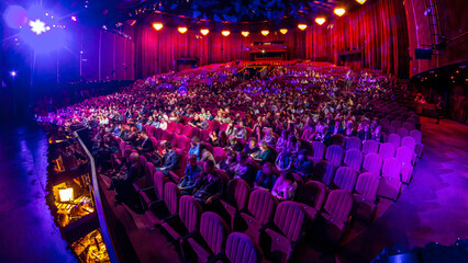 Spectators gather in the auditorium and watch the show in theatre timelapse. Large hall with red...