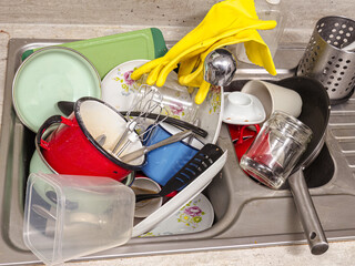 Kitchen sink full of dirty kitchenware
