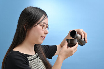 日本酒を飲む若い日本人女性