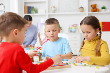 Cute children at white tables during lesson in elementary school