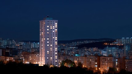 Naklejka premium Night Cityscape View with Illuminated Buildings Against Dark Sky in Modern Urban Environment