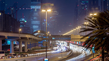 Traffic on intersection and bridge at the Sheikh Zayed Road day to night timelapse