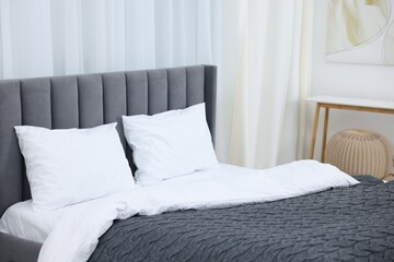 Bed with fresh white linens and gray blanket indoors, closeup
