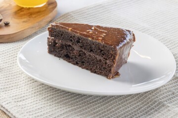 Chocolate cake slice with caramel icing on plate