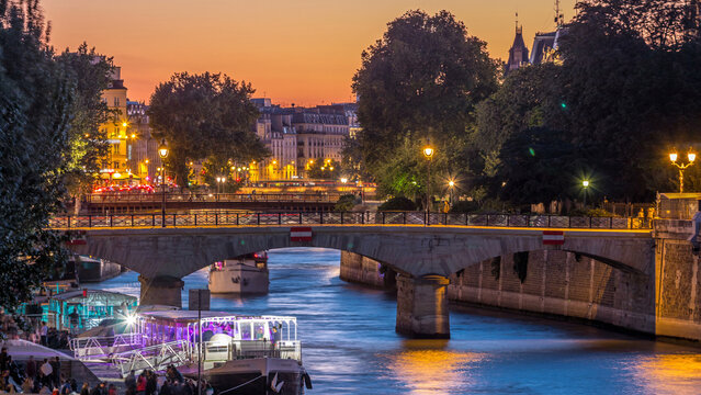 River and bridge near Notre Dame De Paris cathedral day to night timelapse after sunset.