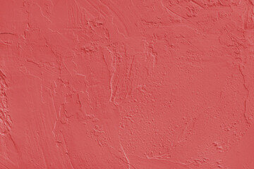 Close up, macro of red painted textured stucco wall with rough plaster, concrete surface texture. Abstract background, backdrop for design, wallpaper art or decoration projects.