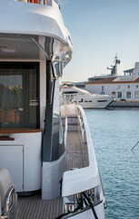 A sleek yacht’s side deck with polished chrome railings and teak wood flooring, docked peacefully in a marina at Limassol Marina